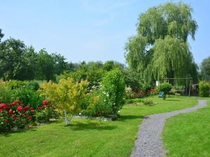 un camino a través de un jardín con flores y árboles en Cléome, en Arques-la-Bataille