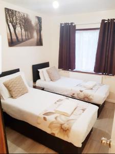a room with two beds and a window at The 55 in Enfield +13 photos