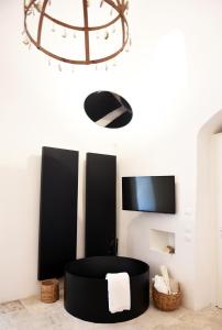 a black chair in a room with a tv at Arya Nobile Dimora in Carovigno