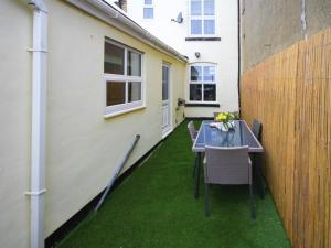 a patio with a table and chairs on the grass at Colliery Cottage in Durham