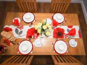 a table with red and white plates and flowers on it at Colliery Cottage in Durham
