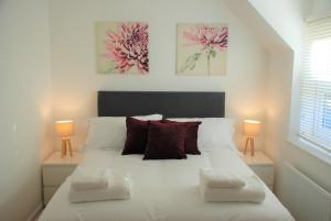 a bedroom with a large white bed with two lamps at Coach House in Southampton