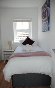um quarto com uma cama grande e uma janela em Coach House em Southampton