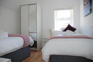 1 dormitorio con 2 camas y ventana en Coach House en Southampton