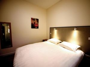 una camera da letto con un grande letto bianco con due cuscini di THE COACHING BARNS a Shrewsbury