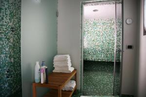 a bathroom with a shower with towels on a table at Il Sole Di Ranco in Ranco