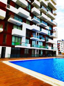 a building with a swimming pool in front of it at Uptown holiday app daily rental contactless Check In & Check Out in Famagusta