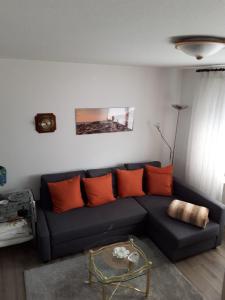 een woonkamer met een blauwe bank en oranje kussens bij Ferienwohnung Hummer im Haus Daheim in Helgoland