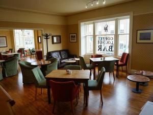 a restaurant with tables and chairs and a couch at The Corner House Hotel in Annan