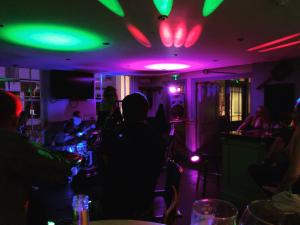 un groupe de personnes dans un bar avec des feux verts dans l'établissement The Cornubia Inn, à Hayle