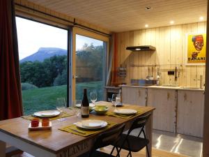 a wooden table in a kitchen with a large window at Gite Basse Correo in La Freissinouse