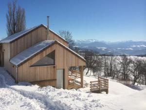 a small wooden building in the snow with a bench at Gite Basse Correo in La Freissinouse
