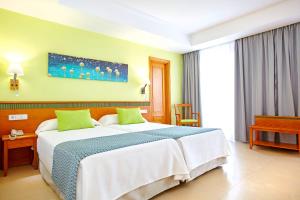 A bed or beds in a room at Universal Hotel Laguna