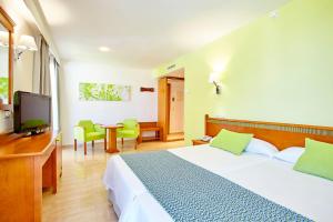 A bed or beds in a room at Universal Hotel Laguna