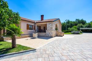 a house with a brick driveway in front of it at Villa Križanci in Žminj