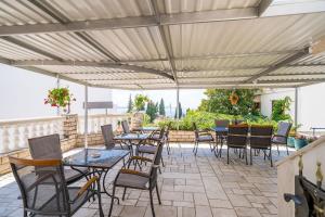 a patio with tables and chairs under awning at Villa Marija Adriatic in Mlini