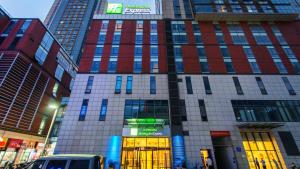 un palazzo alto con un cartello sulla parte anteriore di Holiday Inn Express Changzhou Centre, an IHG Hotel a Changzhou