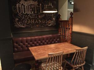 une table et des chaises dans un restaurant avec une cabine en cuir dans l'établissement The Crafty Cow, à Bristol