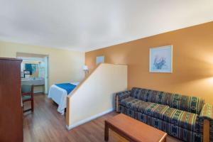 a hotel room with a couch and a bed at Travel Inn Kingman Route 66 in Kingman +4 photos