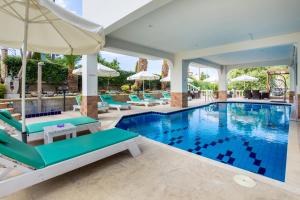 利邁納里亞的住宿－戈爾登公寓式酒店，一个带椅子和遮阳伞的游泳池