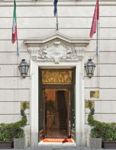 einen Eingang zu einem Gebäude mit zwei Flaggen über der Tür in der Unterkunft Residenza Antica Roma in Rom