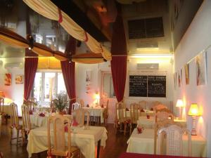 a restaurant with white tables and chairs and a chalkboard at Hôtel Le Richevaux in Neufchâteau