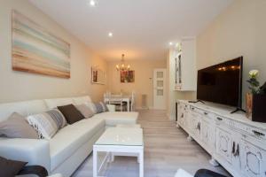 a living room with a white couch and a flat screen tv at Impresionante apartamento Palacio de Congresos in Granada