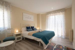 sypialnia z łóżkiem z niebieskimi poduszkami w obiekcie Impresionante apartamento Palacio de Congresos w Grenadzie