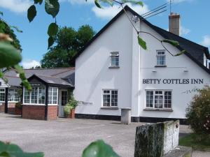 a large white building with a sign on the front of it at Betty Cottles Inn in Okehampton