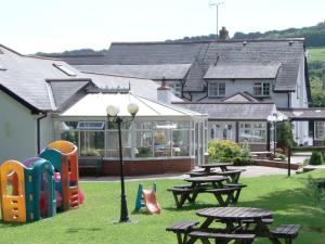 a picnic table and chairs in front of a house at Betty Cottles Inn in Okehampton