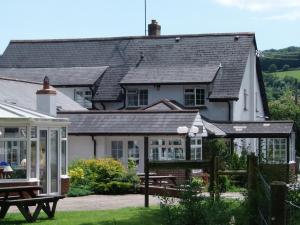 a house with a wooden roof and a white house at Betty Cottles Inn in Okehampton