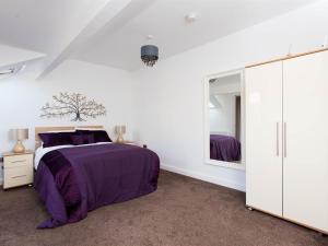 Luxurious Serviced Apartments في ليدز: غرفة نوم بسرير ومرآة كبيرة