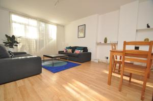 a living room with two couches and a table at Large Garden flat in the heart of Islington in London