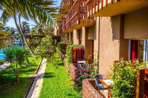 a building with tables and chairs next to a garden at Hotel Jardin Savana Dakar in Dakar