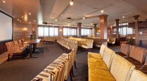 a waiting room with chairs and tables and a podium at Grand Hotel Beatrix in Den Helder