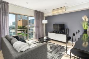uma sala de estar com um sofá e uma televisão em Icon Apartments na Cidade do Cabo