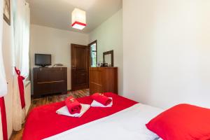 a bedroom with a red bed with red towels on it at Apartament Olivia Zakopane in Zakopane