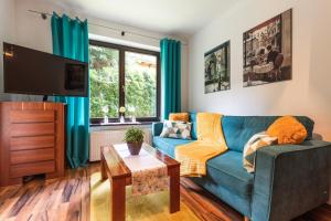 a living room with a blue couch and a tv at Apartament Olivia Zakopane in Zakopane