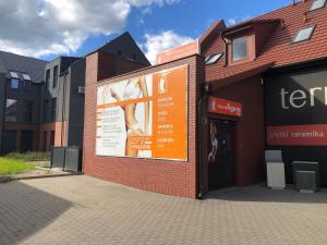 een gebouw met een oranje bord aan de zijkant bij Apartament - Loft in Piła
