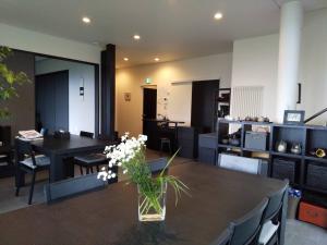 a dining room with a table with a vase of flowers on it at KEI in Lake Toya