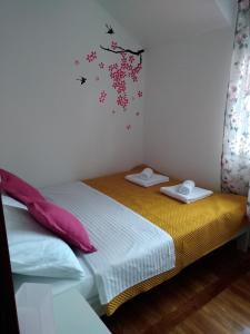 um pequeno quarto com duas camas e pássaros na parede em Sweet Apartment em Zaječar