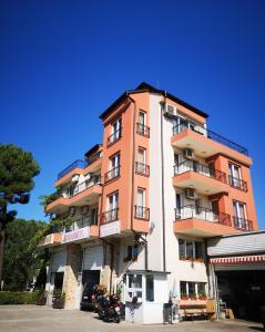a tall orange building with balconies on top of it at Respekt Guest House in Sunny Beach