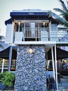 a building with a stone wall in front of it at Royale Chenang Resort in Pantai Cenang