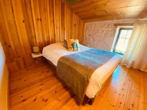 a bedroom with a bed in a wooden cabin at Refuge de Campagne "la Grange à Mémé " in Chaix