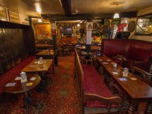 a restaurant with wooden tables and chairs in a room at Crown and Trumpet Inn in Broadway