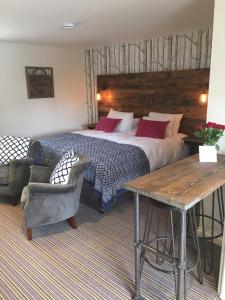 a bedroom with a bed and a table and a chair at The Crown, Hutton le Hole in Hutton le Hole