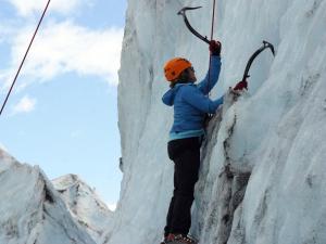 una persona está escalando un muro de hielo en Carriage House Accommodations en Girdwood