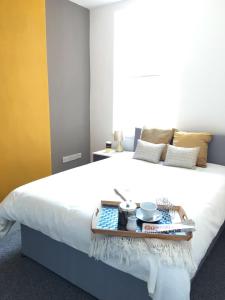 a white bed with a tray of food on it at Townhouse @ 97 Edleston Road Crewe in Crewe