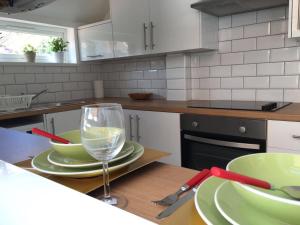 a kitchen with green plates and a wine glass at Townhouse @ 97 Edleston Road Crewe in Crewe