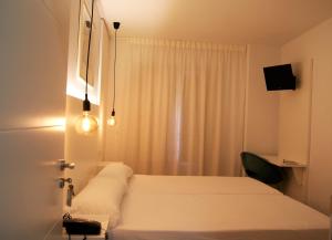 a bedroom with a white bed and a window at Hotel La Encomienda in Moraleja